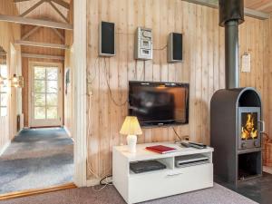 ein Wohnzimmer mit einem TV und einer Holzwand in der Unterkunft Holiday Home Nanja - 759m from the sea in NW Jutland by Interhome in Løkken