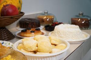 une table avec des assiettes de beignets et d'autres pâtisseries dans l'établissement Honório pousada - Tucano BA, à Tucano