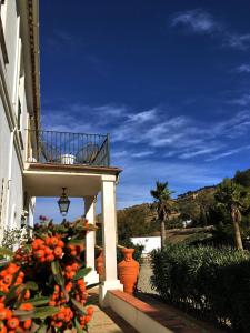 um edifício com uma varanda com flores de laranja ao lado em La Sorpresa em Valle de Abdalagís