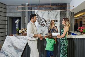 un homme et une femme et un enfant debout à côté d'un comptoir dans l'établissement Optimum Luxury Hotel&Spa, à Antalya