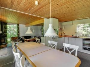 een keuken en eetkamer met een tafel en stoelen bij Holiday Home Fot - 7km from the sea in Djursland and Mols by Interhome in Ebeltoft