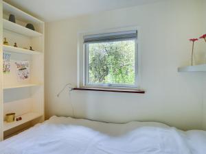 een slaapkamer met een bed en een raam bij Holiday Home Fot - 7km from the sea in Djursland and Mols by Interhome in Ebeltoft