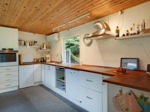 een keuken met witte kasten en een houten plafond bij Holiday Home Fot - 7km from the sea in Djursland and Mols by Interhome in Ebeltoft