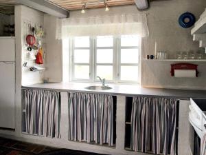 uma cozinha com um lavatório e uma janela em Holiday Home Genta - 100m from the sea in NW Jutland by Interhome em Lokken