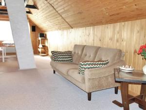 uma sala de estar com um sofá e uma mesa em Holiday Home Genta - 100m from the sea in NW Jutland by Interhome em Lokken