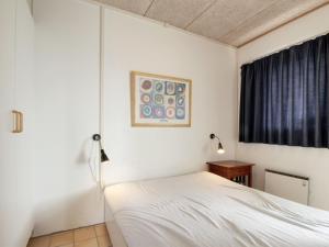 um quarto com uma cama branca e uma janela em Apartment Tomte - 70m from the sea in NW Jutland by Interhome em Lokken