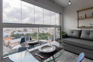 a living room with a glass table and a couch at Contemporary Studio - GRU in Guarulhos