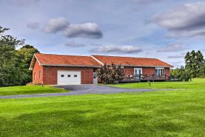 een rood bakstenen huis met een grote groene tuin bij Updated Home with Lake Views on Cayuga Wine Trail! in Ovid