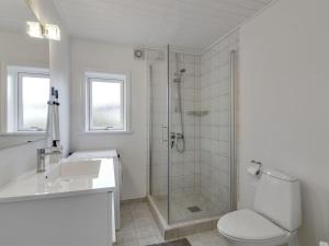 a bathroom with a shower and a toilet and a sink at Holiday Home Nehat - 300m from the sea in NW Jutland by Interhome in Løkken