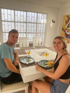 een man en vrouw aan een tafel met borden eten bij Alojamiento Arte y Salud in Cartagena