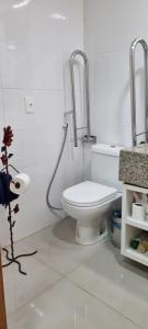 a white bathroom with a toilet and a sink at Apartamento linda vista no Brisas do Lago, Brasília in Brasília