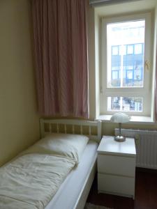 a small bedroom with a bed and a window at 470er Ferienwohnung in Laboe
