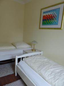 a bedroom with two beds and a picture on the wall at 470er Ferienwohnung in Laboe