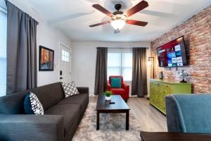 ein Wohnzimmer mit einem Sofa und einem Deckenventilator in der Unterkunft Trendy Escape ◉ California King bed awaits! in Charlotte