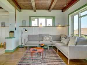 uma sala de estar com um sofá e uma mesa em Holiday Home Quirina - 75m from the sea in NW Jutland by Interhome em Torsted