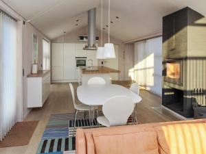 cocina y sala de estar con mesa blanca y sillas en Holiday Home Erko - 150m from the sea in NW Jutland by Interhome, en Løkken