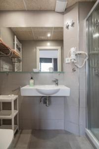 y baño con lavabo y espejo. en Hostal House, en Barcelona
