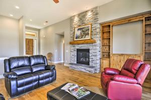 een woonkamer met lederen meubels en een stenen open haard bij Chic Willamette Valley Home with Deck and Vineyard! in Gaston