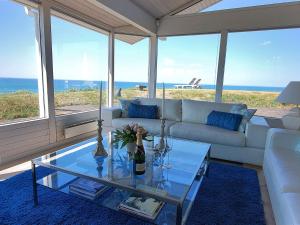 ein Wohnzimmer mit einem Sofa und einem Glastisch in der Unterkunft Holiday Home Alyssa - 300m from the sea in NW Jutland by Interhome in Løkken