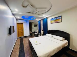 a bedroom with a bed and a tv in it at AAKAS HOTEL & RESTAURANT in Muzaffarabad