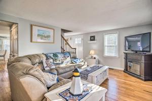 a living room with a couch and a tv at Walk to Great Pond Spacious East Falmouth Home in East Falmouth