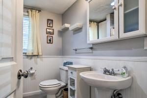 a bathroom with a white toilet and a sink at Walk to Great Pond Spacious East Falmouth Home in East Falmouth +23 photos