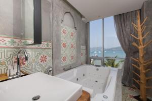 ein Badezimmer mit Badewanne und großem Fenster in der Unterkunft Patong Signature Boutique Hotel in Patong Beach