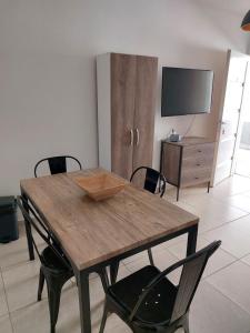 una mesa de madera y sillas en una habitación con TV en Departamento centrico, en San Luis