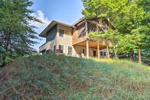 a house on top of a grassy hill at Forested Pentwater Vacation Rental - Walk to Beach in Pentwater