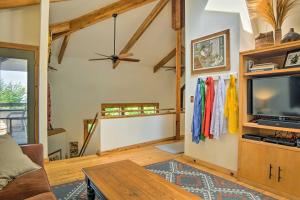 a living room with a ceiling fan and a tv at Forested Pentwater Vacation Rental - Walk to Beach in Pentwater