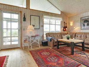 een woonkamer met een bank en een tafel bij Holiday Home Jerker - 400m from the sea in NW Jutland by Interhome in Løkken