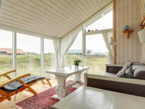 een woonkamer met een tafel en een bank bij Holiday Home Jerker - 400m from the sea in NW Jutland by Interhome in Løkken