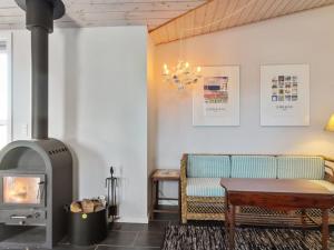 a living room with a wood stove and a couch at Holiday Home Fabio - 450m from the sea in NW Jutland by Interhome in Løkken