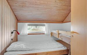 a small bed in a tiny house with a window at Lovely Home In Hurup Thy With Kitchen in Sindrup