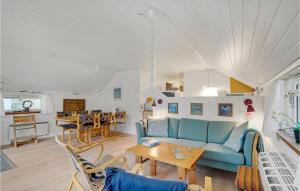 a living room with a blue couch and a table at Holiday Home Klydevej Hurup Thy Xi in Sindrup