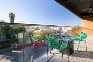 a balcony with a table and chairs and a view of a city at Eazy Centro by ULIV in Tijuana