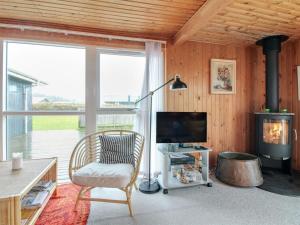 a living room with a chair and a fireplace at Holiday Home Thurid - 200m from the sea in NW Jutland by Interhome in Løkken