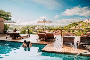 two people in the swimming pool at a resort at Jubarte Hotel - Tawa Beach Club in Búzios