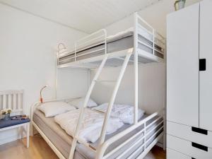 een slaapkamer met een stapelbed in een witte kamer bij Apartment Meglena - 50m from the sea in NW Jutland by Interhome in Løkken