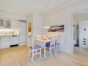 een keuken en eetkamer met een tafel en stoelen bij Apartment Meglena - 50m from the sea in NW Jutland by Interhome in Løkken
