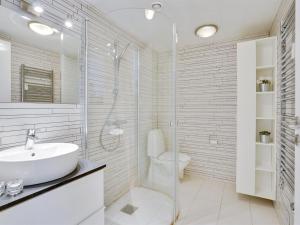 een witte badkamer met een wastafel en een toilet bij Apartment Meglena - 50m from the sea in NW Jutland by Interhome in Løkken