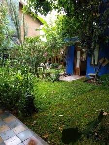uma casa com um quintal com uma casa azul em Cozy studio with lovely garden em Tigre