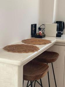 a kitchen counter with a table with two stools at Thealos Santorini ( close to square) in Pyrgos