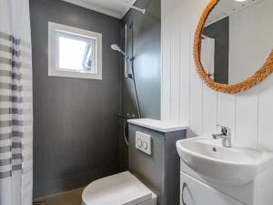 y baño con lavabo, aseo y espejo. en Holiday Home Adelita - 100m from the sea in NW Jutland by Interhome, en Løkken