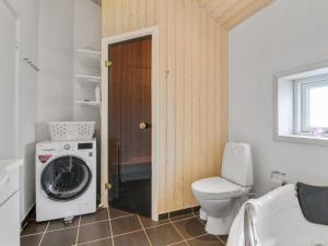 een badkamer met een toilet en een wasmachine bij Holiday Home Anett - 400m from the sea in NW Jutland by Interhome in Løkken