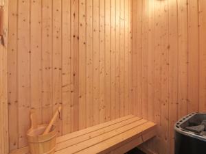 een houten bank in een sauna met een vuilnisbak bij Holiday Home Anett - 400m from the sea in NW Jutland by Interhome in Løkken
