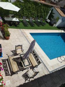 a swimming pool with chairs and a umbrella and a swimming pool at Casa Capricho del Destino 