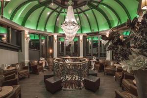 a restaurant with a green ceiling and chairs and a chandelier at Europa Hotel Kühlungsborn in Kühlungsborn