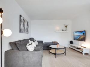 een woonkamer met een bank en een tafel bij Holiday Home Gudlaug - 400m from the sea in NW Jutland by Interhome in Blokhus