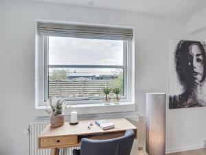 a desk and chair in a room with a window at Holiday Home Gudlaug - 400m from the sea in NW Jutland by Interhome in Blokhus